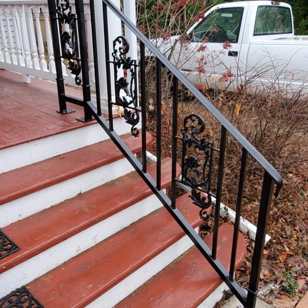 6 ft ornamental black railing with 3 cast dragon pieces inserted into the railing between vertical pickets.