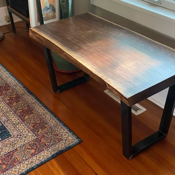 Side profile of a 2" live edge walnut bench with steel trapezoid legs