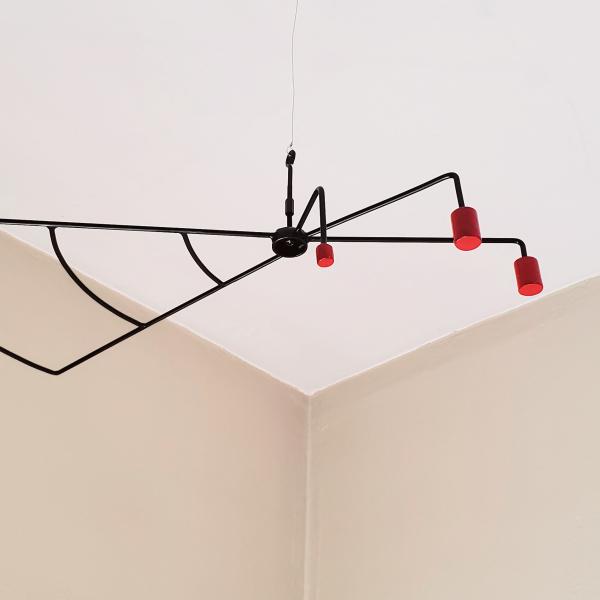 Orthographic view of a modern hanging sculpture.  1/4" round steel is bent to look similar to a wing or fan on one side of this sculpture while 3 red steel slugs counter balance the other side.  Painted black round and painted red steel slugs.