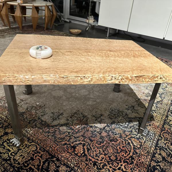 Bird's eye maple table top sit on a steel table frame with sculpted lion paw feet