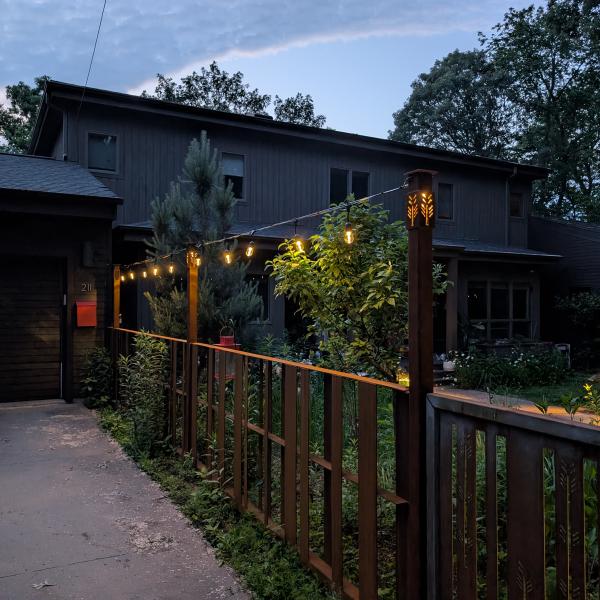 Cor 10 fence with gate and illuminated posts along a drive way