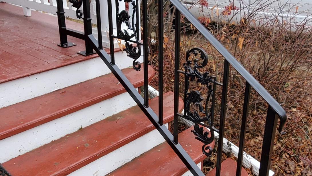 6 ft ornamental black railing with 3 cast dragon pieces inserted into the railing between vertical pickets.