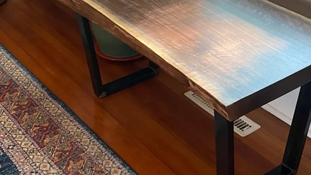 Side profile of a 2" live edge walnut bench with steel trapezoid legs