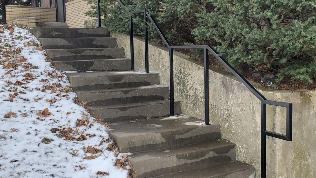 black 1-1/2" square tubing was used on this out door railing going up a concrete stair case