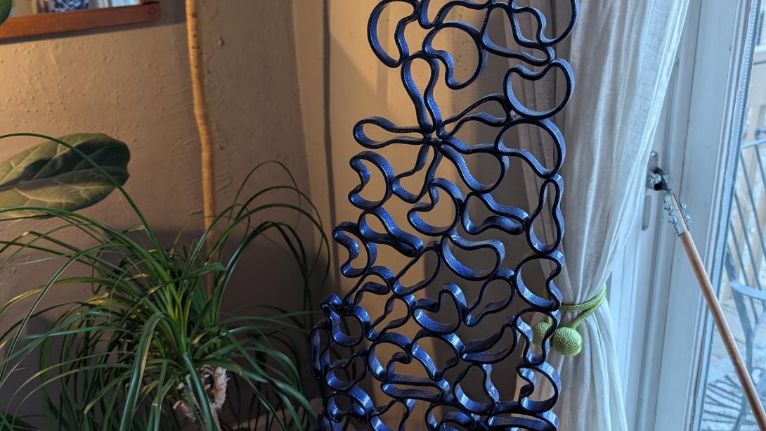 sculpture of metal rings heated and manipulated to look like blue cells fastened into stone