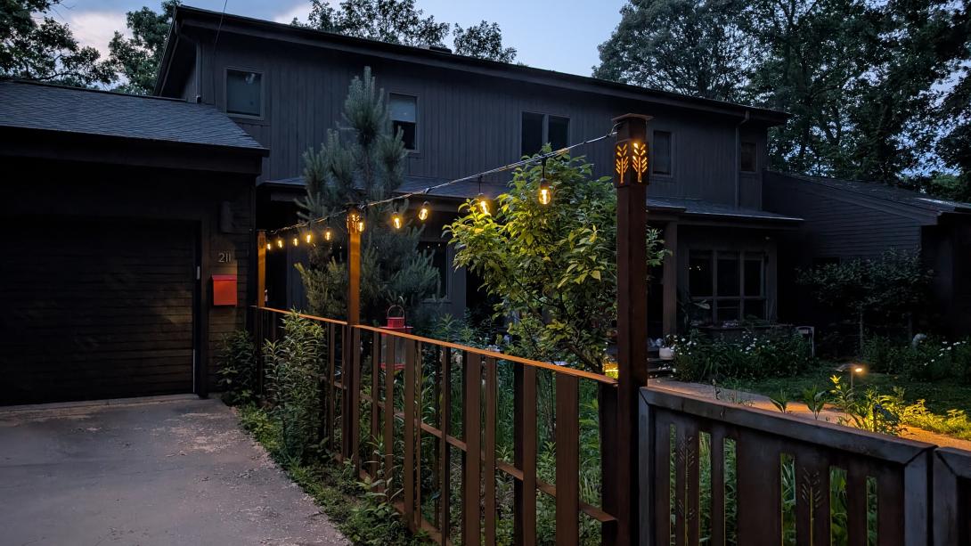 Cor 10 fence with gate and illuminated posts along a drive way
